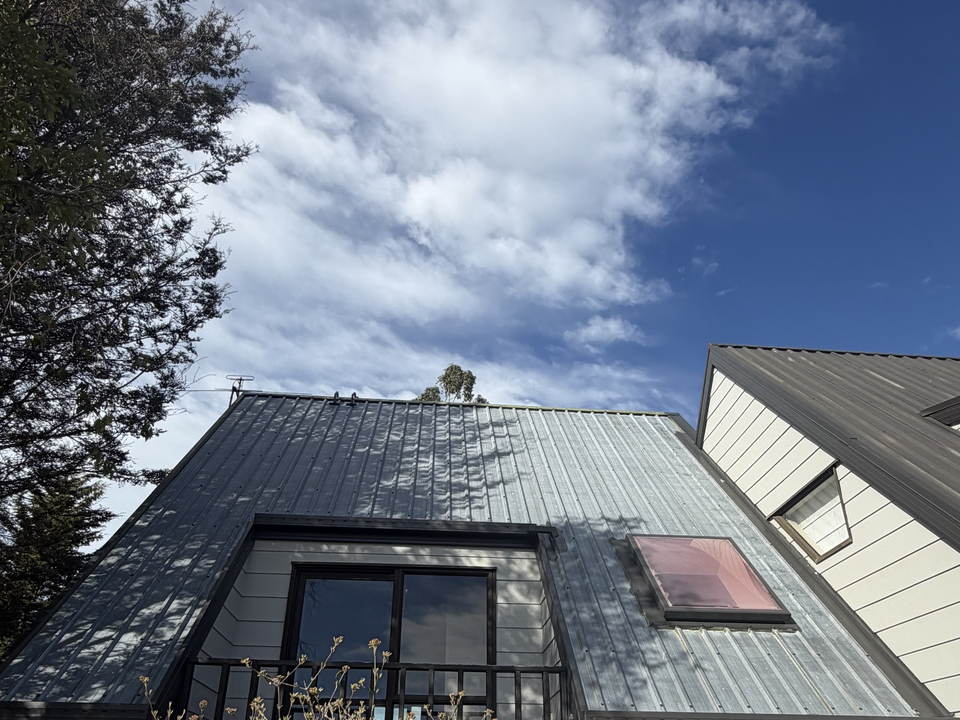 Before: the same Kaiapoi roof faded to a patchy light grey, with the dormer and skylight below