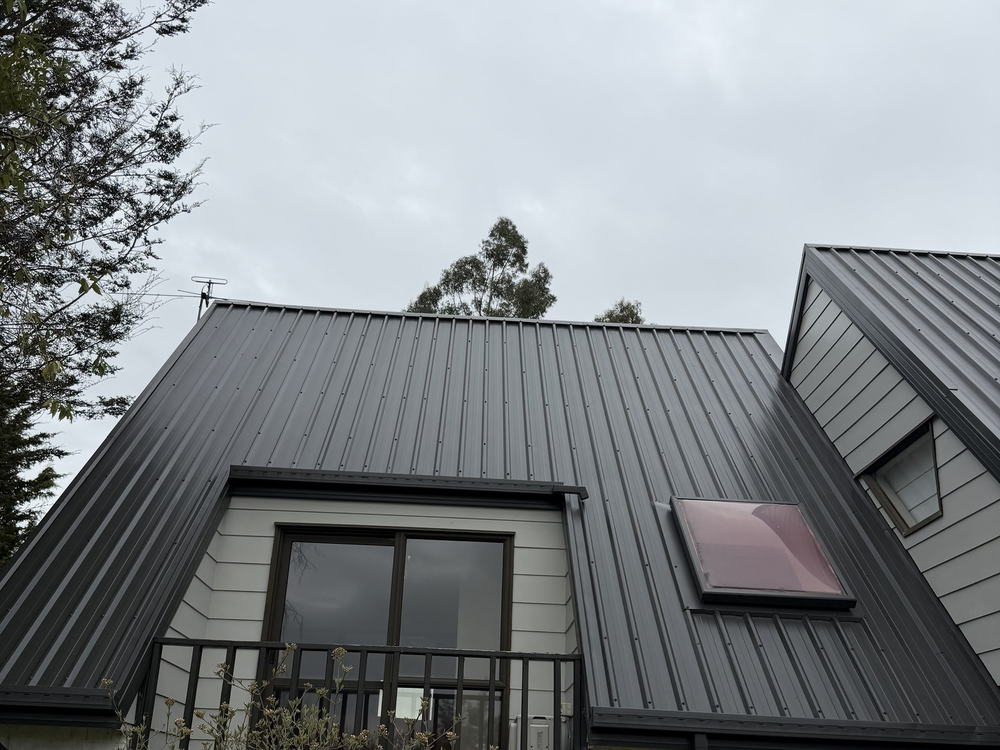 Kaiapoi two storey house with its long-run roof freshly painted charcoal