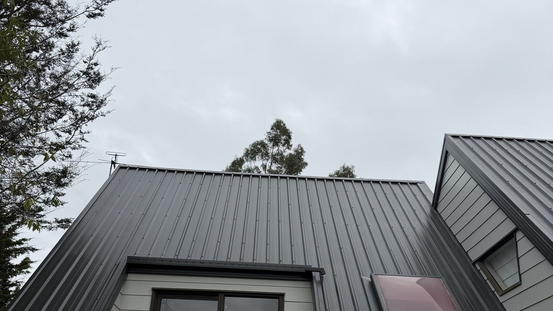 Freshly painted charcoal long-run roof on a Kaiapoi home, the finish even across the whole slope